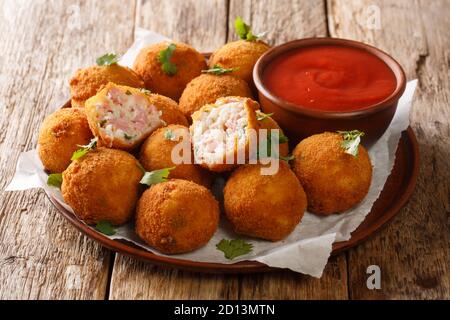 Populaire plat chaud hors-d'œuvre boules de choucroute farcies au jambon servi avec ketchup gros plan dans une assiette sur la table. Horizontal Banque D'Images