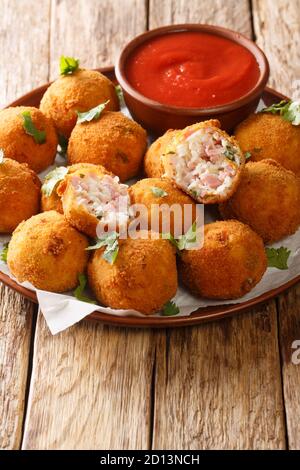 Délicieux hors-d'œuvre boules de Sauerkraut avec du jambon en gros plan dans une assiette sur la table. Vertical Banque D'Images