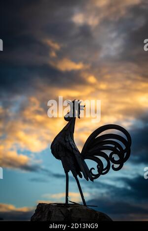 Une silhouette de coq noir, symbole du Chianti, se démarquent d'un ciel de coucher de soleil orageux dans le village de Vertine, en Toscane Banque D'Images