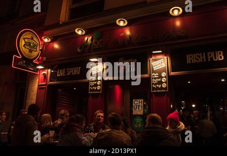 PARIS, FRANCE - 7 DÉCEMBRE 2019 : les gens boivent de la bière et se socialisent sur la terrasse du pub irlandais Hide le soir dans la rue Lombards célèbre pour ses clubs de jazz Banque D'Images