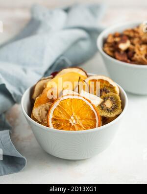 fruits séchés orange, banane, kiwi, poire, mangue, fraises dans un bol bleu en gros plan Banque D'Images