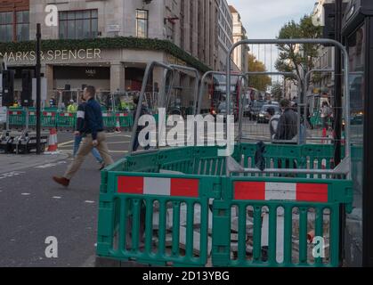 Les gens ont vu traverser la rue devant les travaux de voirie à Londres. Banque D'Images