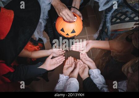 Mains d'enfants attendant que des bonbons soient distribués sur Halloween Banque D'Images