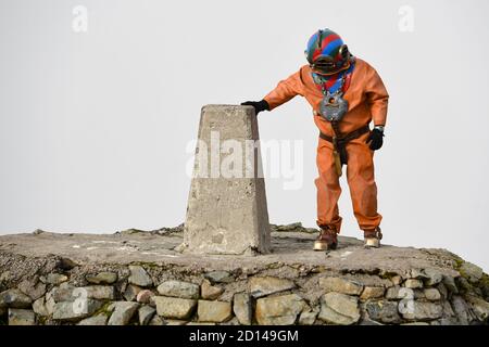 Lloyd Scott, collecteur de fonds vétéran, qui tente de grimper les trois sommets tout en portant un costume de plongée en haute mer, au sommet de Ben Nevis en Écosse. Banque D'Images