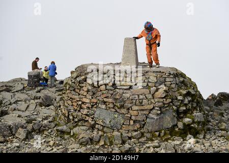 Lloyd Scott, collecteur de fonds vétéran, qui tente de grimper les trois sommets tout en portant un costume de plongée en haute mer, au sommet de Ben Nevis en Écosse. Banque D'Images