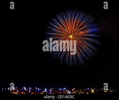 Feux d'artifice. Feux d'artifice colorés étonnants dans fond de ciel sombre et lumière de maison floue dans le lointain à Zurrieq, Malte Festival des feux d'artifice, 4 de juillet, Banque D'Images