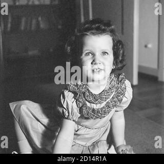 Vintage années 1950 style de vie , deux ans Old Girl pose pour caméra dans sa jolie robe, Etats-Unis Banque D'Images