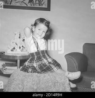 Vintage années 1950 style de vie , deux ans Old Girl pose pour caméra dans son pull à carreaux, États-Unis Banque D'Images