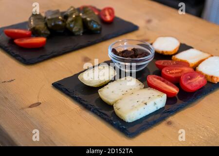 Différents types de fromages délicieux et savoureux, avec tomates cerises et olives grecques noires isolées. Plus de nourriture comme la bruschetta italienne et le hoummus en b Banque D'Images