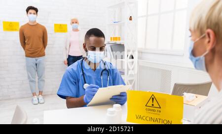 Médecin travaillant avec des patients pendant la campagne de vaccination contre le coronavirus à l'hôpital Banque D'Images