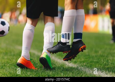 Coup de pied gratuit de football. Les joueurs se randent dans un mur de football. Des pieds de footballeurs qui sautent dans un mur. Joueurs de sport et de chaussettes de football Whte Banque D'Images