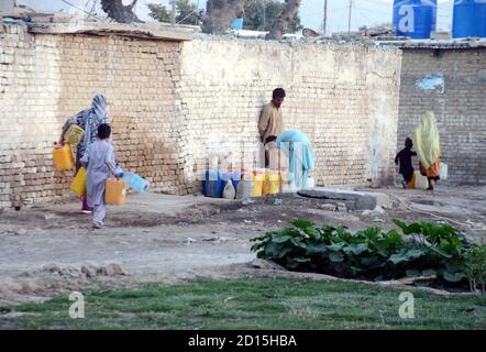 Les citoyens remplissent leurs bidons d'eau du robinet public alors qu'ils sont confrontés à une pénurie d'eau potable dans leur région par temps chaud, à la colonie ferroviaire de Quetta, le lundi 05 octobre 2020. Banque D'Images