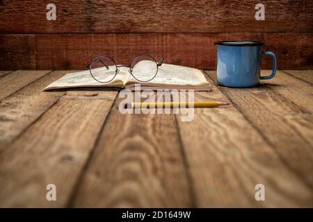 Journal d'expédition vintage sur une table de pique-nique rustique avec une tasse de thé - écriture et dessin dans le journal de voyage (autorisation de propriété jointe), sélectif Banque D'Images