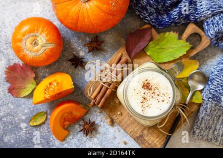 Latte épicée à la citrouille d'automne ou café en verre avec des ingrédients biologiques sur un comptoir en pierre légère. Vue de dessus de l'arrière-plan de la mise à plat Banque D'Images