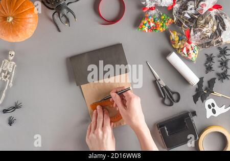 Emballage étape par étape d'un cadeau pour Halloween. Étape 6 - à l'aide d'une règle, marquez les fenêtres de la maison avec un stylo feutre Banque D'Images