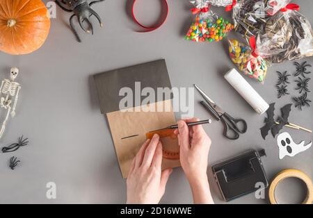 Emballage étape par étape d'un cadeau pour Halloween. Étape 7 - à l'aide d'une règle, marquez la deuxième fenêtre de la maison avec un stylo feutre Banque D'Images