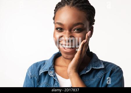 Bonne dame afro-américaine avec des accolades posant sur fond blanc Banque D'Images