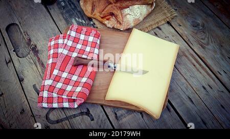 Morceaux de fromage d'abondance sur une planche à découper Banque D'Images