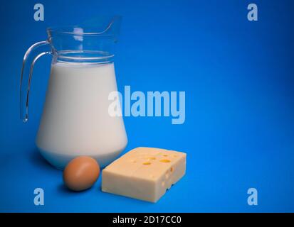 Produits laitiers. Lait, œuf et fromage sur fond bleu. Banque D'Images