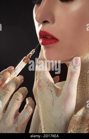 Fille avec le maquillage créatif se fait des injections dans le visage Banque D'Images