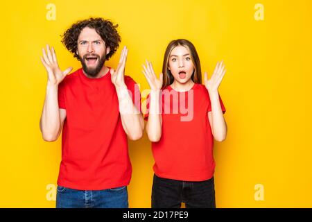 Photo d'un petit ami et d'une petite amie excités avec une bouche ouverte isolée sur fond jaune Banque D'Images