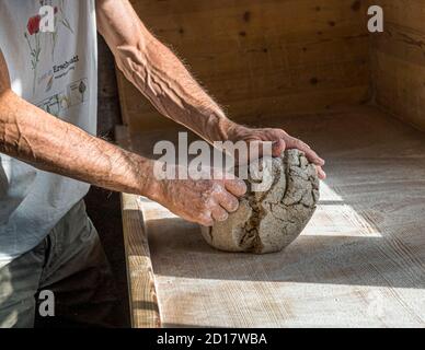 Atelier traditionnel de pain en seigle du Valais à Goppenstein-Erschmatt, Suisse. Avant que les participants de l'atelier de cuisson du pain se mettent au travail, Edmund Steiner montre comment travailler les bords arrondis et les crevasses de la pâte de seigle Banque D'Images