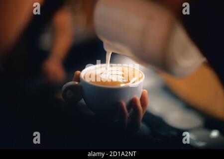 Barista pouring latte foame professionnel autour d'un café, espresso et cappuccino créer un Banque D'Images