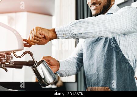Homme afro-américain Barista préparant du café avec une machine à café professionnelle Banque D'Images
