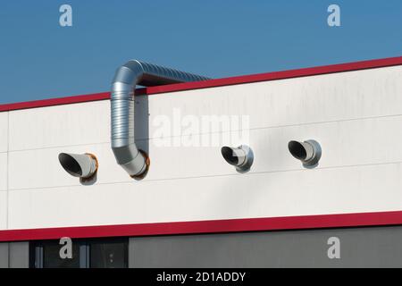 Conduits d'air en acier inoxydable sur un toit rouge Banque D'Images