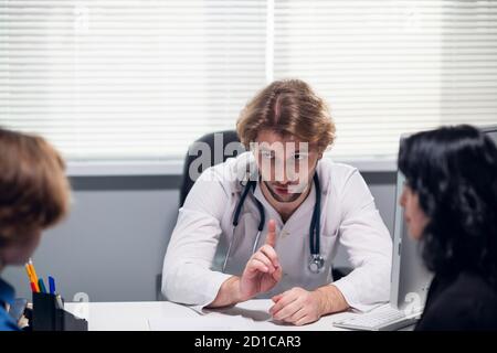 Un médecin de famille effectuant un examen médical, posant des questions, prenant des notes. Banque D'Images