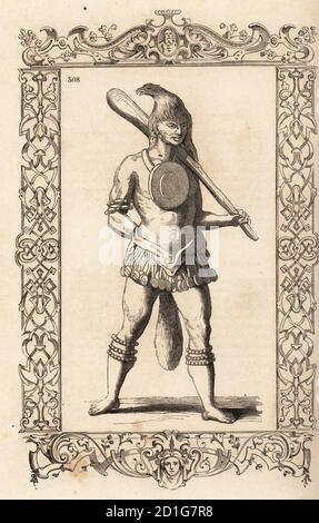 Costume d'un chef de Timucua, Floride. Il porte une tête d'aigle, un grand disque sur sa poitrine, un chiffon, des bracelets et des anklets, une grande queue de chat et porte un grand club. Costume de chef. Adapté d'une gravure de Theodor de Bry d'après Jacques le Moyne. Dans un cadre décoratif gravé par H. Catenacci et Fellmann. Gravure de blocs de bois par Gerard Seguin et E.F. Huyot d'après Christoph Krieger de Cesare Vecellio costumes anciens et modernes, habitudes antichi et moderni di tutto il mondo, Firman Didot Ferris fils, Paris, 1859-1860. Banque D'Images