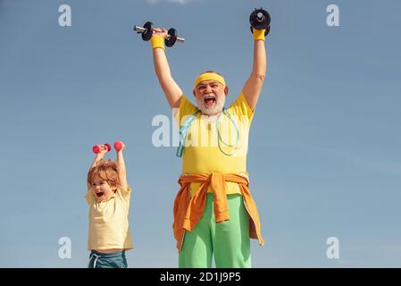 L'âge n'est pas une excuse pour prendre du mou sur votre santé. Garçon fait des exercices pour développer des muscles. Le père et le fils construisent des biceps et des triceps. Grand-père et fils Banque D'Images