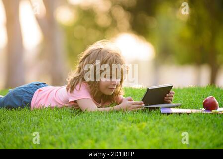 Enfant mignon garçon étudie et apprend dehors. Banque D'Images