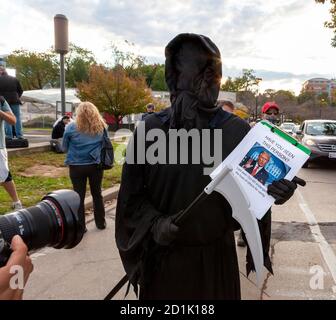 Bethesda, MD, États-Unis, 5 octobre 2020. En photo : une personne habillée comme la Grim Reaper porte une faucille et une planchette à pince avec une photo de Donal Trump et le titre, « avez-vous vu cette personne ? » Sous la photo, la fiche indique qu'il a été "vu pour la dernière fois le 4 octobre mettant en danger la vie des autres pour la vanité". Les partisans de Trump se sont rassemblés devant le Walter Reed National Military Medical Center où il a été hospitalisé pour Covid-19. Les fans du président sont venus montrer leur soutien pendant les quatre jours où il est resté à l'hôpital après avoir contracté le nouveau coronavirus. Crédit : Allison C Bailey/Alay Live Banque D'Images