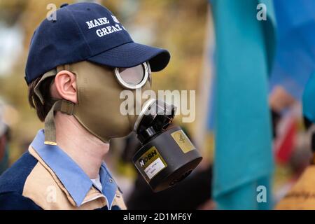 Bethesda, MD, États-Unis, 5 octobre 2020. En photo : un homme portant un chapeau Make America Great Again et un masque à gaz de style israélien se promenait autour de la distribution de sandwiches de glace parmi les partisans de Trump rassemblés devant le centre médical militaire national Walter Reed. Le Président y a hospitalisé pour le covid-19 après avoir contracté le nouveau coronavirus. Crédit : Allison C Bailey/Alay Live News Banque D'Images