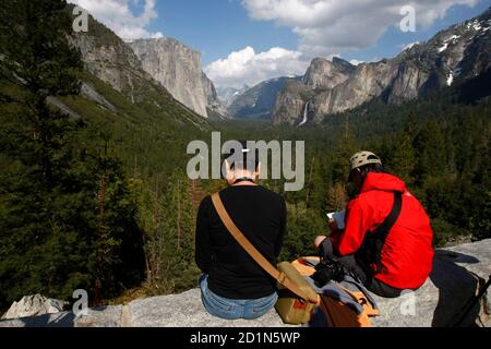 Les touristes apprécient la vue sur la vallée de Yosemite, avec ses monuments El Capitan, Half Dome et Bridalveil Fall, au parc national de Yosemite en Californie le 19 avril 2008. REUTERS/Darrin Zammit Lupi (ÉTATS-UNIS)