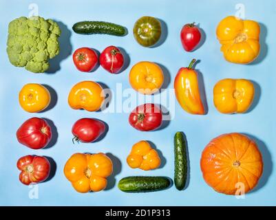 Différents légumes frais de ferme disposés sur fond bleu. Vue de dessus. Banque D'Images