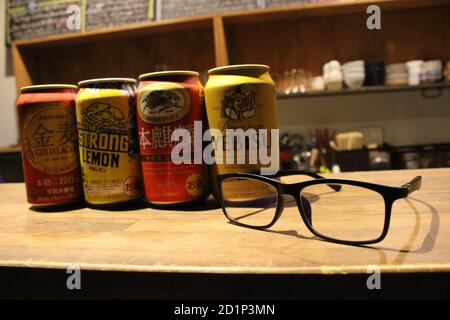 Gros plan sur les canettes de bière japonaises (Kirin, Suntory, Yebisu) et les lunettes. Banque D'Images