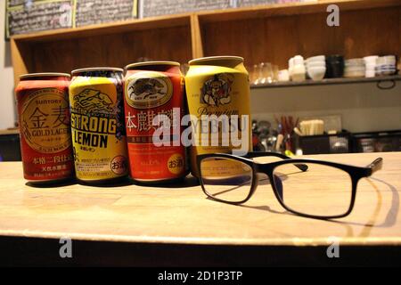 Gros plan sur les canettes de bière japonaises (Kirin, Suntory, Yebisu) et les lunettes. Banque D'Images