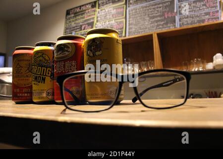 Gros plan sur les canettes de bière japonaises (Kirin, Suntory, Yebisu) et les lunettes. Banque D'Images