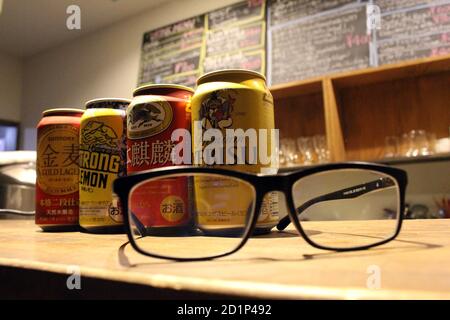 Gros plan sur les canettes de bière japonaises (Kirin, Suntory, Yebisu) et les lunettes. Banque D'Images