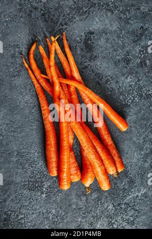 La nourriture est horrible. Carottes organiques déformées sur fond bleu. Produits déformés, problème de déchets alimentaires concept. Pose à plat Banque D'Images