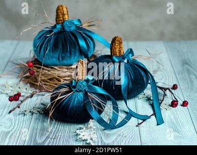 De belles citrouilles bleues en velours sont décorées de divers éléments et rubans . Décoration pour les fêtes d'Halloween. Décoration de Noël Banque D'Images