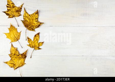 Bouquet d'automne de feuilles d'érable dorées sur fond de bois. Concept tendance. Pose en flanelle dans un style minimaliste Banque D'Images