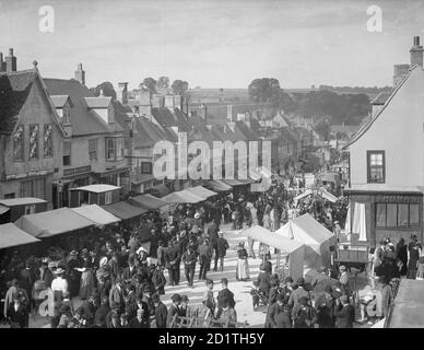 High Street, Burford, Oxfordshire. Vue sur la rue pendant le salon de l'embauche (salon MOP) avec stands. Banque D'Images