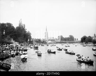 MARLOW, Wycombe, Buckinghamshire. Une vue sur la rivière remplie de petits bateaux à rames et de bateaux à moteur pendant la régate tenue chaque année entre 1855 et 2001 sur la Tamise (elle a depuis été transférée au lac Dorney). Avec l'église de la Toussaint et le pont suspendu au-delà. Photographié en 1885 par Henry Taunt. Banque D'Images