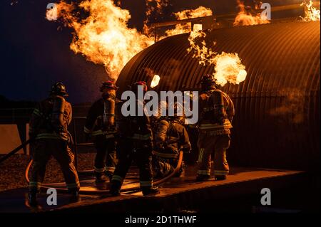 Les pompiers du 436e Escadron de génie civil et de la station 55 de la compagnie de pompiers volontaires Magnolia, du Delaware, se préparent à entrer dans un entraîneur d'incendie d'avion lors d'un exercice d'entraînement à la base aérienne de Douvres, Delaware, le 22 septembre 2020. Les températures à l'intérieur de l'entraîneur d'incendie de l'avion peuvent atteindre 1,500 degrés Fahrenheit. (É.-U. Photo de la Force aérienne par le premier Airman Christopher Quail) Banque D'Images