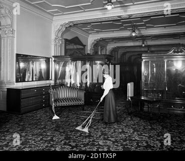 GRAND MAGASIN FREDERICK GORRINGE, 75 Buckingham Palace Road, Londres. Vue de l'intérieur. Une femme qui présente les dernières technologies d'aspiration. Gorringe's avait ouvert ses portes dans les années 1900, et a finalement fermé ses portes dans les années 1960. Photographié par Bedford Lemere & Co en 1910. Banque D'Images