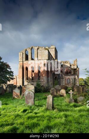 Vue générale des vestiges du prieuré depuis l'est, avec son cimetière au premier plan, Lanerost, Cumbria, Royaume-Uni. Banque D'Images