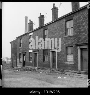 L'extérieur du 2-8 Sparrow Street avec la cheminée de Monarch Mill en poking sur les toits, Oldham, Greater Manchester, Royaume-Uni. Banque D'Images